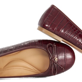 Dune burgundy croc-embossed leather ballet flats with bow detail and tan insole, shown from above and side angle.
