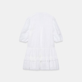 White tiered mini dress with puff sleeves, broderie anglaise trim, and button placket, shown from the back