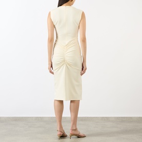 Model wearing Jacquemus off-white sleeveless dress with ruched back detail, styled with nude heeled mules, rear view.