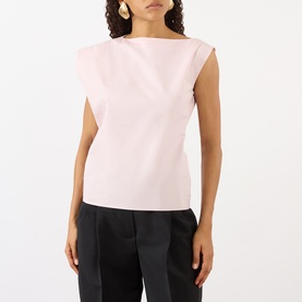 Model wearing Jacquemus light pink cotton sleeveless top with boat neckline and structured shoulders, styled with black trousers.