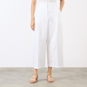 Model wearing Jacquemus white wide-leg cropped cotton trousers, styled with nude strappy flat sandals