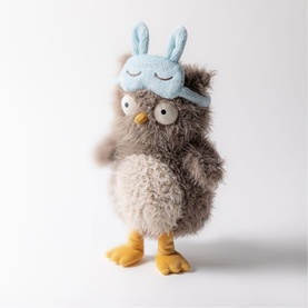 Jellycat fluffy brown owl plush toy with yellow feet and light blue bunny ear sleep mask, standing upright