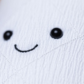 Jellycat Amuseables white plush soft toy close-up showing embroidered smiley face detail with black button eyes