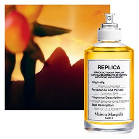 Maison Martin Margiela Replica EDT spray bottle with warm golden tones and tropical fruit backdrop, white label with black text