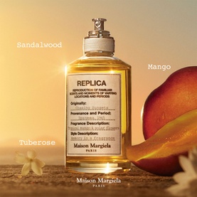 Maison Martin Margiela Replica EDT bottle with sandalwood, mango and tuberose fragrance notes, styled with mango and flowers on warm sandy surface.