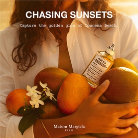 Maison Margiela Replica EDT bottle held by model cradling mangoes and white flowers, warm golden tones, Chasing Sunsets campaign