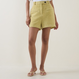 Model wearing Odd Muse Boucl&eacute; Tailored Shorts in chartreuse, high-rise with button fastening, styled with nude strappy heeled sandals