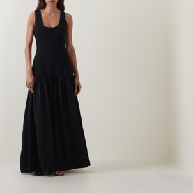Model wearing Odd Muse Dropped Waist Flared Dress in black, sleeveless tank style with dart detail bodice and tiered maxi flared skirt