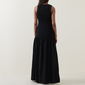 Model wearing Odd Muse Dropped Waist Flared Dress in black, showing rear view with flared maxi skirt and concealed zip fastening.