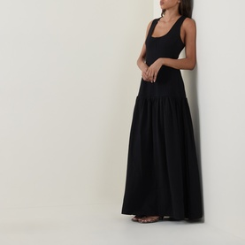 Model wearing Odd Muse Dropped Waist Flared Dress in black, sleeveless tank style with flared maxi skirt, styled with strappy flat sandals