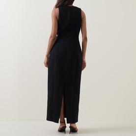 Model wearing Odd Muse Volume Sculpted Dress in black, sleeveless midi length with back slit and waist cinch detail, styled with heeled mules.
