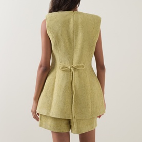 Model wearing Odd Muse Boucl&eacute; Tailored Waistcoat in chartreuse, rear view showing self-tie waist detail, styled with matching shorts.