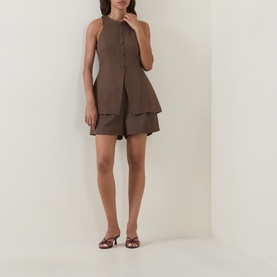 Model wearing Odd Muse Solid Cinched Waistcoat in Mushroom, sleeveless with front buttons and split hem, styled with matching layered shorts and