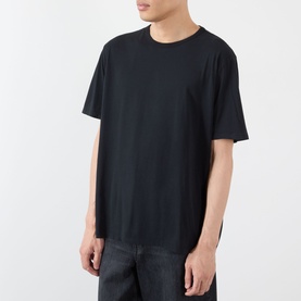 Model wearing Our Legacy black crew neck cotton T-shirt, paired with dark jeans, relaxed fit with dropped shoulders.