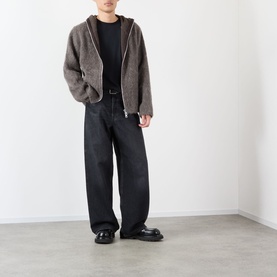 Model wearing Our Legacy black cotton T-shirt, styled with brown zip-up hoodie, wide-leg black trousers and black loafers.