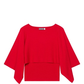 Red cropped top with wide draped cape overlay, batwing-style sleeves, and asymmetric hemline, displayed flat on white background.