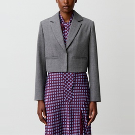Model wearing Claude Pierlot mottled grey cropped blazer with notch lapels, styled with a purple floral print dress.