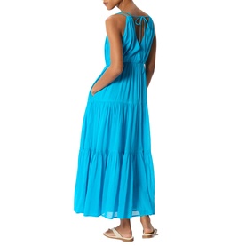 Model wearing Whistles blue tiered maxi dress with tie back detail, styled with white flat sandals, back view shown.