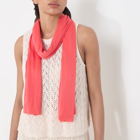 Model with Masai Amega Oblong Scarf in pink, lightweight modal fabric draped around neck, styled with cream sleeveless knit top