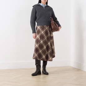 Model wearing Max Mara Weekend dark grey wool knit jumper with brown check midi skirt, black knee-high boots and brown shoulder bag.