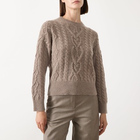 Model wearing taupe cable-knit crew neck jumper with long sleeves, styled with khaki trousers