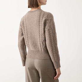 Model wearing a taupe cable-knit crew neck sweater with ribbed hem, styled with matching taupe wide-leg trousers. Rear view.