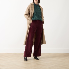 Model wearing Max Mara Weekend Hobby Knitted Sweater in dark green with burgundy wide-leg trousers, camel longline coat, and black heeled boots.