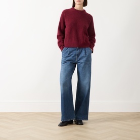 Model wearing Max Mara Weekend Tuono Bordeaux knitted sweater with crew neck and ribbed trims, styled with wide-leg blue jeans and black loafers.