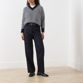 Model wearing Max Mara Weekend navy stripe wool knit V-neck jumper, styled with wide-leg dark trousers and black loafers