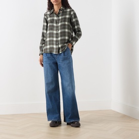 Model wearing Max Mara Weekend khaki check silk shirt with wide-leg blue jeans and dark loafers