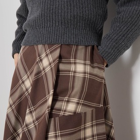 Model wearing Max Mara Weekend brown check pleated skirt in virgin wool blend, styled with a dark grey ribbed knit sweater.