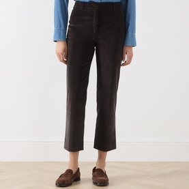 Model wearing Max Mara Weekend dark brown cotton cropped trousers, styled with a blue shirt and brown loafers.