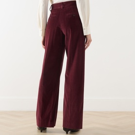 Model wearing Max Mara Weekend Tania Corduroy Straight-Leg Trousers in Bordeaux, wide-leg silhouette with pressed creases, styled with a white blouse.