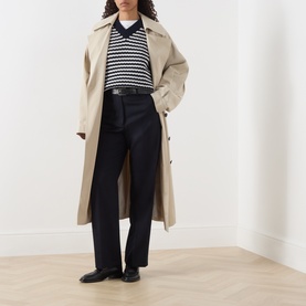 Model wearing Max Mara Weekend Ultramarine wool trousers, styled with a beige trench coat and navy striped knit