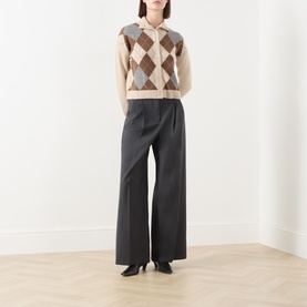 Model wearing Max Mara Weekend dark grey wide-leg virgin wool trousers, styled with an argyle knit vest and black heels.