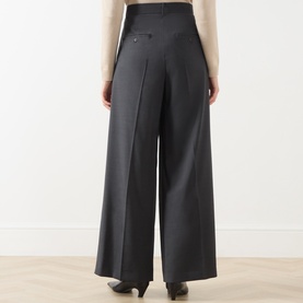 Model wearing Max Mara Weekend dark grey virgin wool wide-leg high-waist trousers, rear view, styled with a cream knit top.