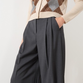 Model wearing Max Mara Weekend dark grey virgin wool wide-leg pleated trousers, styled with a cream argyle knit jumper.