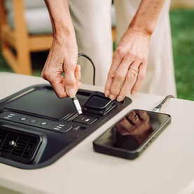 Solo Stove Windchill 47 Cooler & Fan control panel detail, with stylus and smartphone visible on outdoor table