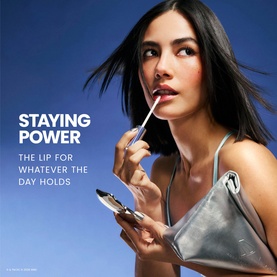 Model with Wonderskin lip make-up set, applying product with wand, holding compact mirror, styled campaign shot with blue sky background