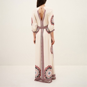 Model wearing Bash cream maxi dress with open back, balloon sleeves, and multicolour embroidered border detail throughout