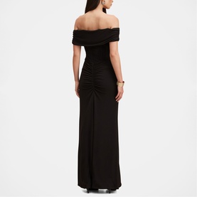 Model wearing Forever New black off-shoulder maxi dress with ruched bodice and side slit, shown from back