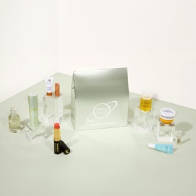 Brown Thomas beauty gift set with silver box, surrounded by miniature skincare, fragrance, and lip colour products