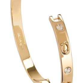 Coach Hinge Bangle Bracelet in shiny gold-tone brass with cubic zirconia stones, horseshoe charm detail, and hinge closure