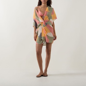 Model wearing Eres Nuance Printed Kaftan in multi-coloured abstract print with twist detail, styled with flat brown sandals.