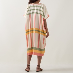 Model wearing Eres multi-stripe silk cover-up dress in pink, green and yellow, styled with brown strappy sandals, rear view