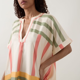 Model wearing Eres multicoloured stripe silk cover-up dress with V-neckline and short sleeves in coral, green and yellow tones