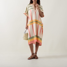 Model wearing Eres Multi silk cover-up dress with short sleeves and V-neck, styled with a wicker bag and brown sandals.