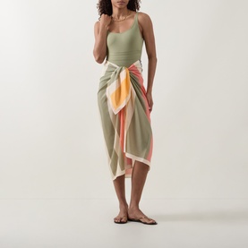Model wearing Eres Croquant Printed Sarong in multi, block stripe print in sage, orange and cream, self-tie wrap style, styled with sage swimsuit and