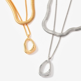 Mint Velvet gold and silver layered snake chain necklaces with open oval drop pendants, shown as a pair