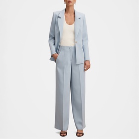 Model wearing Forever New sky blue wide-leg trousers and matching blazer, styled with a white vest top and black heeled sandals